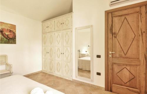 1 dormitorio con puerta de madera y espejo en Stunning Apartment In S,teresa Di Gallura Ot With Kitchen, en Santa Teresa Gallura