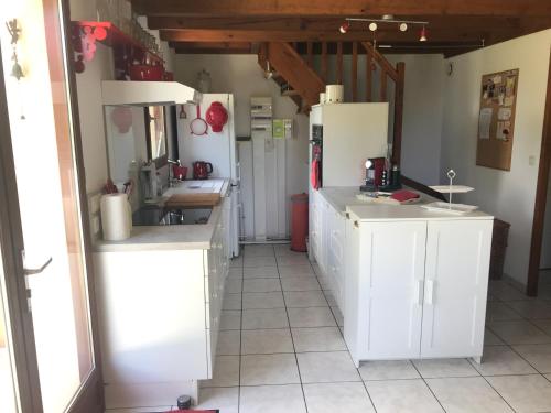 a kitchen with white cabinets and appliances in a room at Maison de vacances village Océlandes in Saint-Julien-en-Born