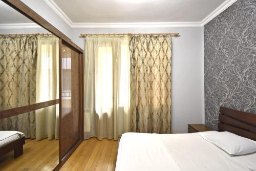 Un dormitorio con una cama y una ventana con cortinas. en Byuzand7 new building in Republic Square, en Ereván