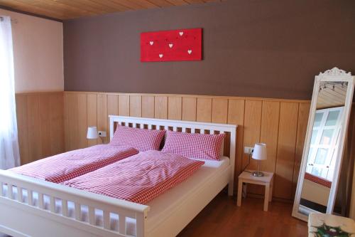 a bedroom with a bed with pink sheets and a red painting at FeWo Alte Post in Oberdigisheim