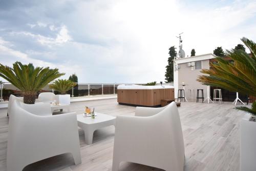 a patio with white chairs and tables on a roof at Tenuta Micoli in Frisa