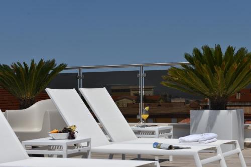 a row of white lounge chairs on a roof at Tenuta Micoli in Frisa