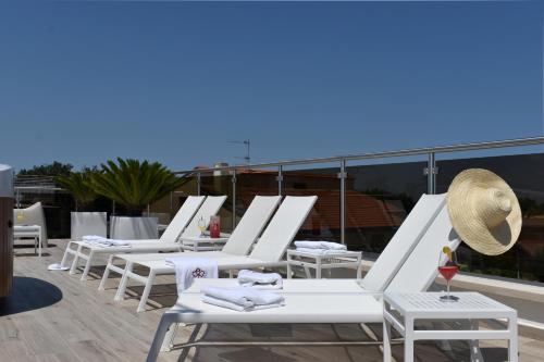 a row of white lounge chairs on a roof at Tenuta Micoli in Frisa