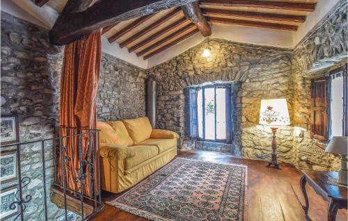 sala de estar con sofá y pared de piedra en 1 Bedroom Beautiful Home In Comano ms, en Comano