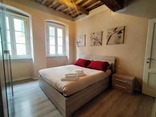 Un dormitorio con una cama con almohadas rojas. en Casa Toscanella & Girasole en Pescia