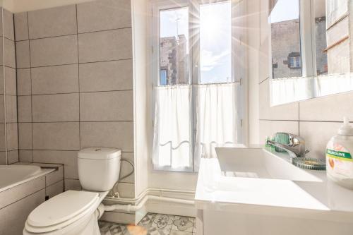 une salle de bain avec toilettes, baignoire et lavabo dans l'établissement Le Panorama, à Clermont-Ferrand