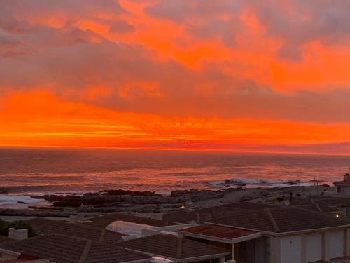 a sunset view of the ocean from a building at Whales & Waves in Hermanus
