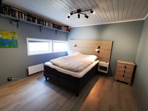 a bedroom with a bed with a wooden headboard at Lofoten, Markveien Villa in Kabelvåg