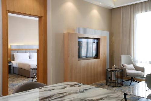 a hotel room with a bed and a chair at Grand Plaza Hotel - Jazan in Jazan