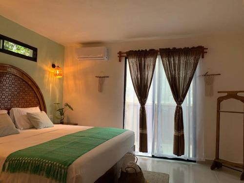 ein Schlafzimmer mit einem Bett und einem großen Fenster in der Unterkunft Private Full House with pool and cozy patio in Valladolid
