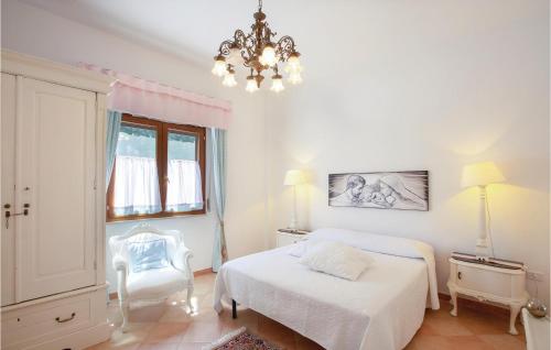 - une chambre blanche avec 2 lits et un lustre dans l'établissement 2 Bedroom Stunning Home In Carovigno br, à Carovigno