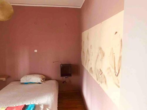 a bedroom with a bed and a painting on the wall at Nice Apartment Near City Center in Athens