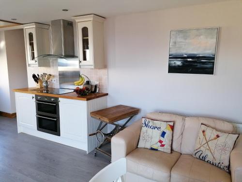 a living room with a couch and a kitchen at Sunnyside House in Gardenstown