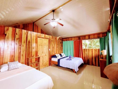 a bedroom with two beds and a ceiling fan at The Sunset Tucano Lodge in Drake
