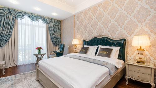 Schlafzimmer mit einem großen Bett mit einem grünen Kopfteil in der Unterkunft GREGORY Boutique Hotel Chisinau in Chişinău