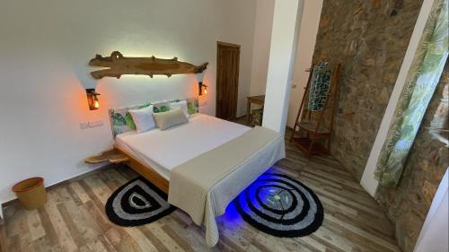 1 dormitorio con cama y pared de piedra en Dune Towers en Alankuda