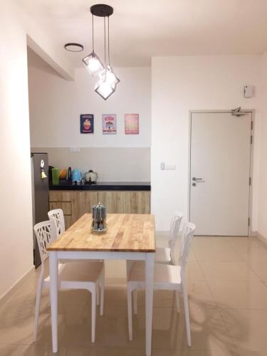 a dining room with a table and white chairs at Del’s Guesthouse @ Southville Same Level with Pool fits 8 in Bangi