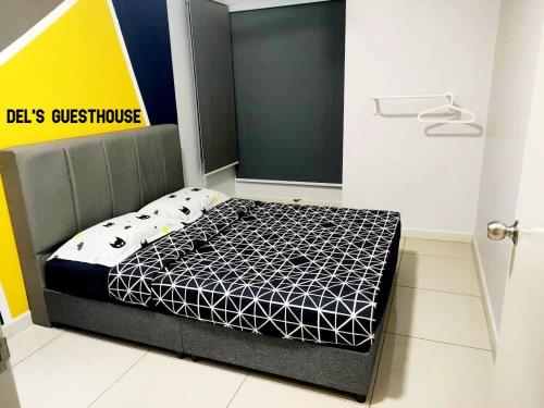 a bedroom with a bed with a black and white comforter at Del’s Guesthouse @ Southville Same Level with Pool fits 8 in Bangi
