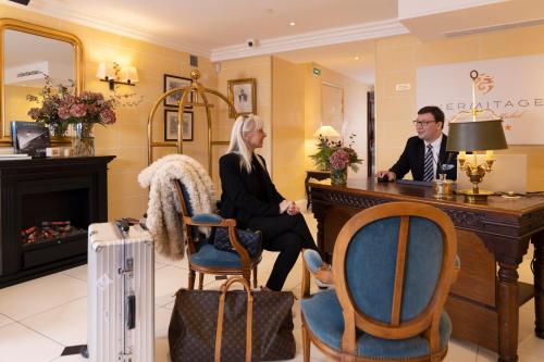 a man and a woman sitting at a desk in a salon at Ermitage - Mont-Saint-Michel in Beauvoir