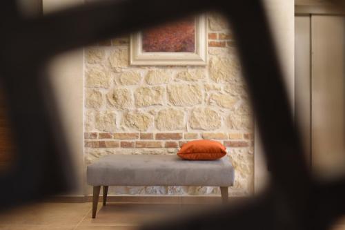 a pillow sitting on a bench in front of a brick wall at Tenuta Micoli in Frisa