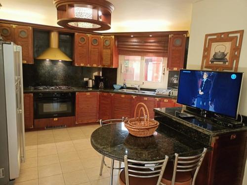 a kitchen with a table with a television on it at Beautiful Luxurious Villa At Stella Di Mare Ain El Sokhna in Ain Sokhna