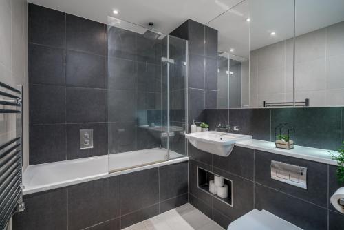 uma casa de banho com uma banheira, um lavatório e um chuveiro em Croydon Saffron Mordern Apartment em Croydon
