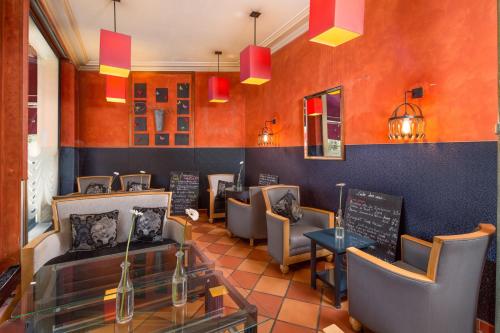 a restaurant with couches and chairs in a room at Hôtel Claret Bercy in Paris