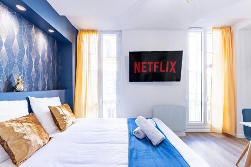 um quarto com uma cama com uma placa de netflix na parede em L'Alcôve Dorée - Appart'Hôtel SPA - Melina & Alfred Agen em Agen