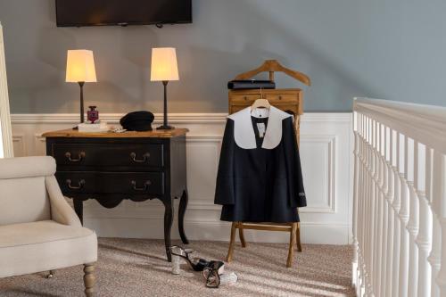 a suit on a mannequin next to a dresser at Ermitage - Mont-Saint-Michel in Beauvoir