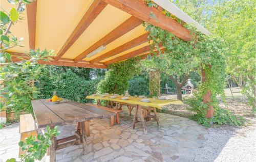 einem Picknicktisch aus Holz unter einer hölzernen Pergola in der Unterkunft Stunning Home In Pesaro -Pu- With Wifi in Gradara