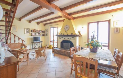 ein Wohnzimmer mit Kamin, Tisch und Stühlen in der Unterkunft Stunning Home In Pesaro -Pu- With Wifi in Gradara
