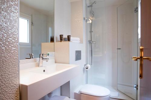 a bathroom with a sink and a toilet and a shower at Hotel Des Deux Continents in Paris