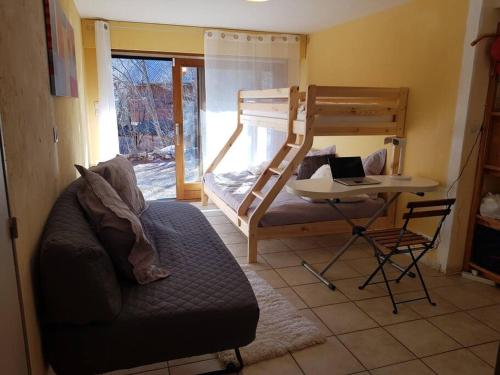 a living room with a bunk bed and a chair at Guidouillette 2 in Le Villaret