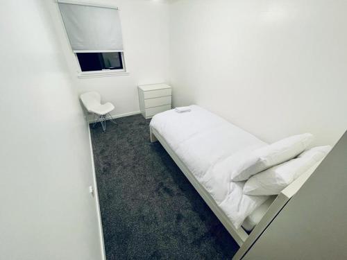 a white bedroom with a bed and a window at Modern 2 Bedroom Apartment With Free Parking in Glasgow