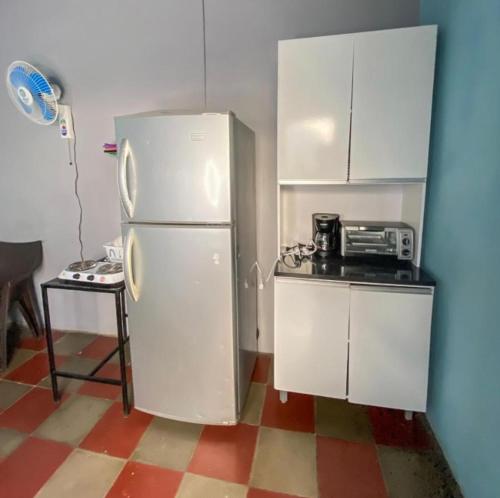 a kitchen with a white refrigerator and a microwave at Hostal Casa Luna in Santa Ana