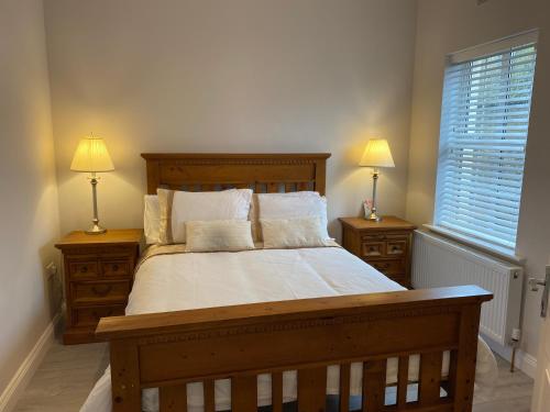 um quarto com uma grande cama de madeira e 2 mesas de cabeceira em Duiche an Rí - Delightful Village Home em Tipperary
