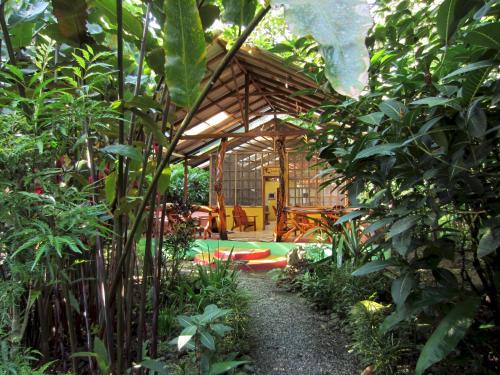 a bamboo house in a garden with plants at Tierra de Sueños Lodge & Wellness Center in Puerto Viejo