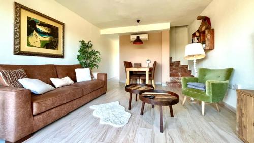 a living room with a brown couch and green chairs at Albirelax in Albir