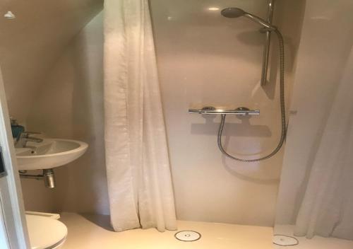 a bathroom with a shower and a toilet and a sink at Parque Biologico de Vinhais in Vinhais