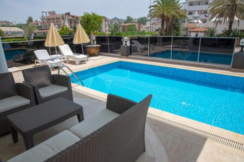 una piscina con 2 sillas, mesa y sillas en Sunrise hill villa with private pool, en Side