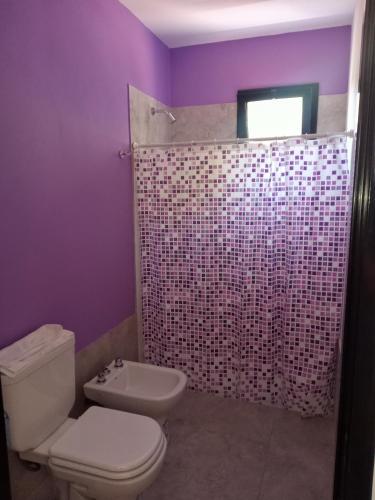 a purple bathroom with a toilet and a shower at Casas del Champaquí in San Javier