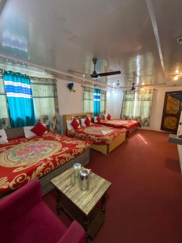 a large room with two beds and a table at Hotel Young Mamta in Srinagar