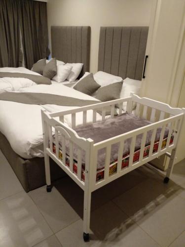 a white crib sitting next to a bed at Villa 55 in 6th Of October