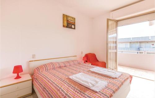 アルバ・アドリアティカにあるAmazing Apartment In Villa Rosa Te With 2 Bedroomsのベッドルーム1室(ベッド1台、赤い椅子、窓付)