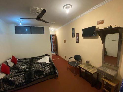 a bedroom with a bed and a mirror and a table at Hotel Young Mamta in Srinagar