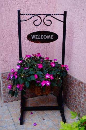 a chair with a welcome sign and flowers on it at Guest House Dara in Tsarevo