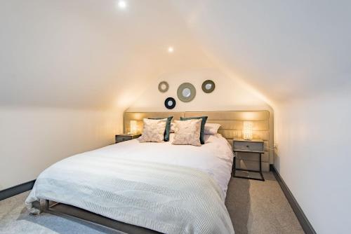 a bedroom with a large white bed with two night stands at Little Seven Oaks by Bloom Stays in Kingswood