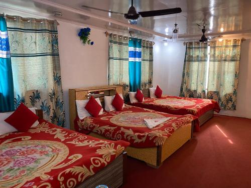 two beds in a room with blue curtains at Hotel Young Mamta in Srinagar