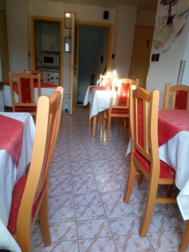 a dining room with tables and chairs and a kitchen at Agria Retur Vendégház in Eger