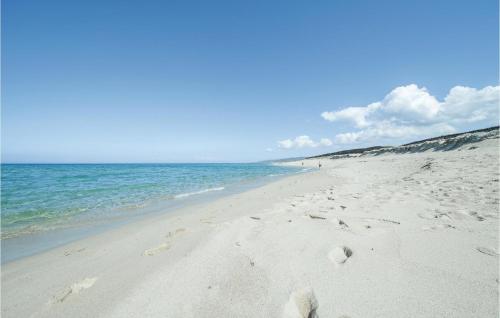 a beach with footprints in the sand and the ocean at Casa Cubo in Flussio